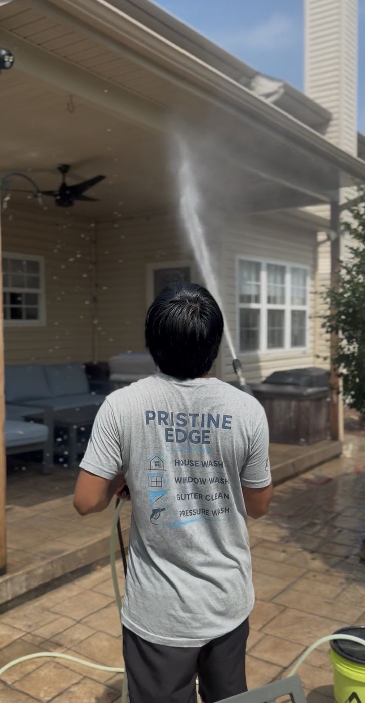 Pristine Edge Cleaning crew member pressure washing a home exterior